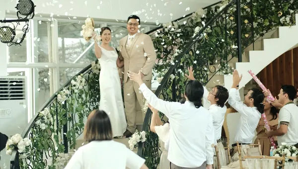 階段の前で、新郎新婦とゲストが手を挙げている写真